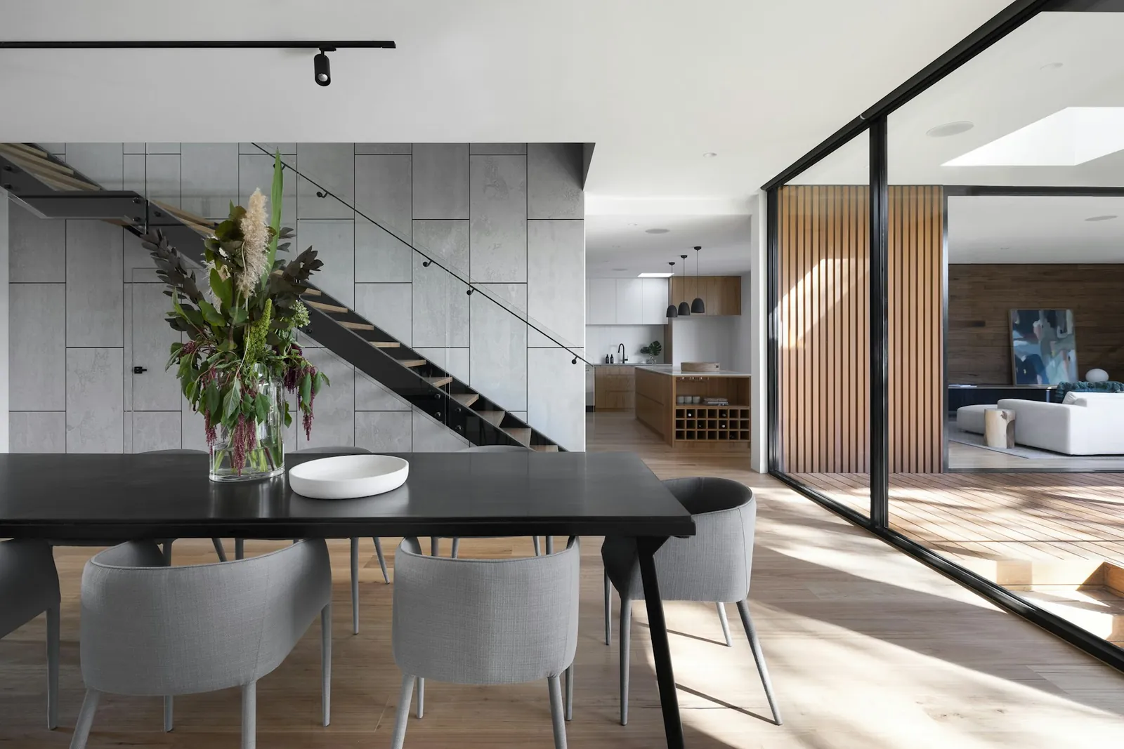 Open dining area with linear pendant and large glazing