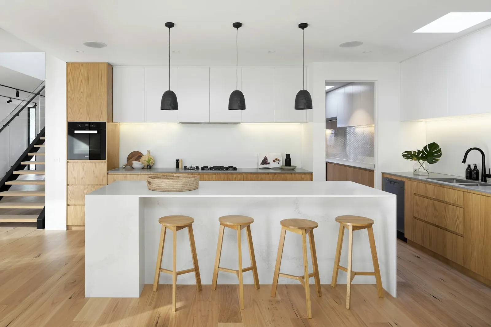 Contemporary kitchen with a stone island, bar stools and pendant lights